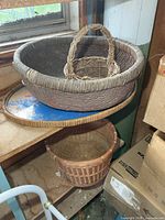 Three wicker baskets and oval tray overall view