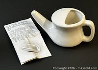Neti pot beside unfolded instruction booklet