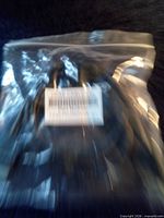 Sealed plastic bag containing coiled black cable with barcode label visible
