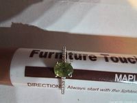 Top view showing oval green peridot and pavé band