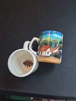 Two mugs, side view of exterior painting and one interior showing cockroach