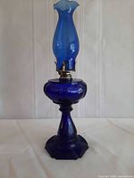 Full view of cobalt blue glass oil lamp with chimney attached