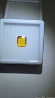 Loose yellow-orange octagon sapphire on display case