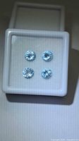Four loose round aquamarines in display box