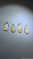 Four leaf-cut citrine gemstones aligned side by side