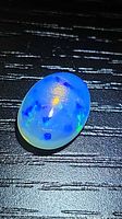 Oval crystal jelly opal showing blue and yellow play-of-color