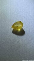 Pear-cut yellow sapphire front view on neutral background