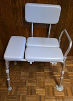 Front view of aluminum bath transfer bench showing padded backrest, three seat pads, single side arm rail and suction cup legs