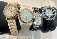 Front view showing all four Geneva watches on display stand