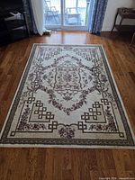 Full view of rug on hardwood floor showing entire pattern and color scheme
