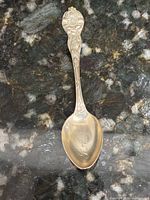 Front view showing floral handle design and monogrammed bowl