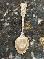 Full view of sterling spoon showing cherub handle and heart-shaped bowl