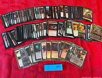 Overall view showing three rows of Magic cards laid out on red cloth, front row sleeved