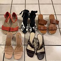 All five pairs of sandals displayed on tiled floor