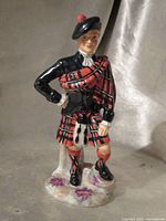 Full front-left view of Radnor Scottish piper bone china figurine