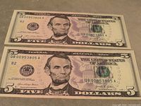 Two consecutive US $5 notes front view