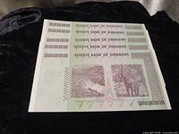 Back side of five 50 Trillion Dollar Zimbabwe notes showing landscape and wildlife design