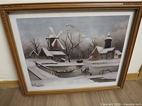Front view of framed H. Rousseau winter village print