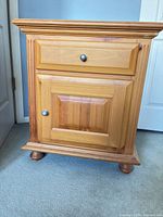 Front view showing drawer, cabinet door and bun feet