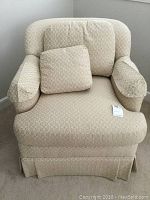 Front view of the Thomasville cream-colored upholstered swivel armchair with matching cushion and arm covers.