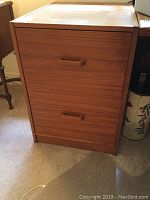 Front view of teak wood two-drawer filing cabinet showing clean wood grain and handles