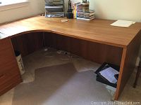 View of the corner desk showing left side, back, and right side with natural wood grain and cable hole visible at the back.