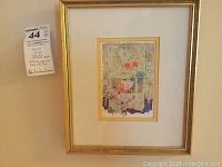 Framed lithograph artwork with seller's lot tag attached to frame