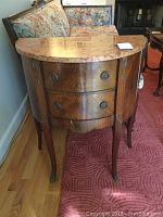 Front view of the demilune side table showing marble top, two drawers, and cabriole legs