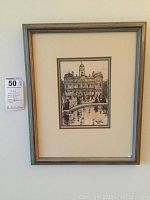 Framed black and white print showing historic city hall building in Lyon with people and fountain.