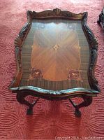 Top view showing the intricate marquetry inlaid tabletop with central and corner motifs and carved edges.