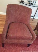 Front view of red upholstered arm chair with rectangular cushion and walnut legs.