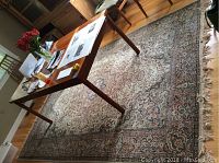 Full view of rug laid under dining table showing overall dimensions and design