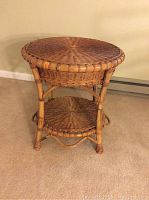 Front and top view of round wicker side table with woven wicker top and lower shelf, bamboo style legs.