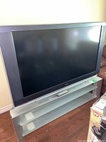 Front view of TV on stand with remote visible