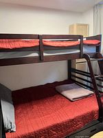Full view of bunk bed assembled showing upper and lower bunks, ladder, guard rail, mattresses, bedding