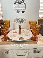 Full lot showing four amber pressed glass goblets surrounding white ceramic divided tray with wood handle