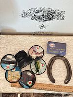 Overall lot showing lens, six discs, Esso box, horseshoe, ruler for scale