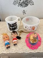 Group shot of mug, bowl, dolls, necklace