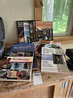 All books spread on workbench showing titles and covers