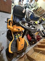 Top view showing steering wheel, seat, yellow body, mower deck