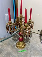 Full view of gold-tone five-arm candelabra with red bead strands and candles