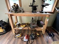 Front view of wooden workbench with tools resting on top and lower shelf visible