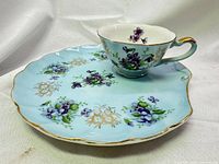 Teacup on saucer displaying full pattern and colors