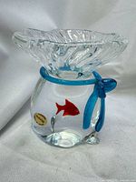 Front view showing fish motif, blue bow, ruffled rim, Murano label