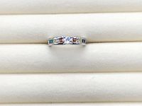 Front view of sterling silver ring with central clear zircon and multicoloured shoulder stones
