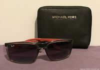 Wallet front with MICHAEL KORS logo and Ray-Ban sunglasses displayed