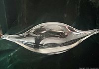 Side profile of clear blown glass bowl showing elongated leaf shape