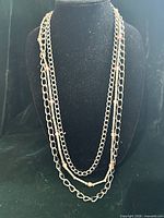 Full view of necklace on bust form showing three strands and overall length