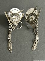 Front view of both earrings showing clock dials, gears, chains, arrow drops