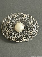 Front view showing floral filigree design and faux pearl centre